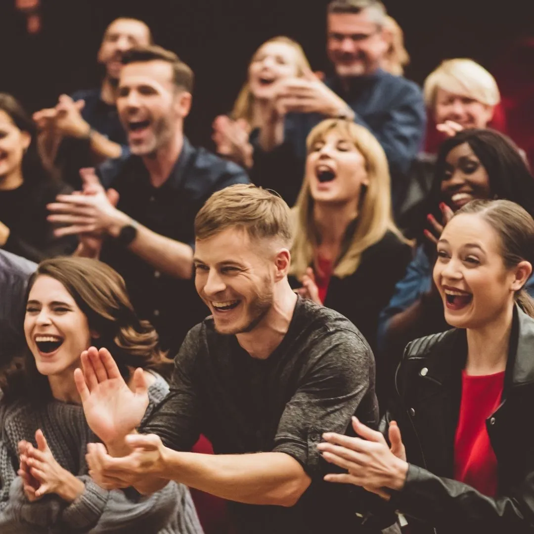 Crowd laughing at comedian for hire