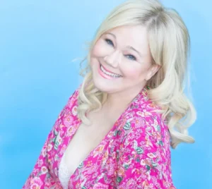 Celebrity comedian for hire Caroline Rhea in a pink floral blouse.