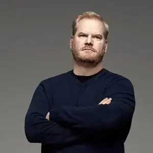 Hire celebrity comedian Jim Gaffigan in a black shirt looking pensive into the distance.
